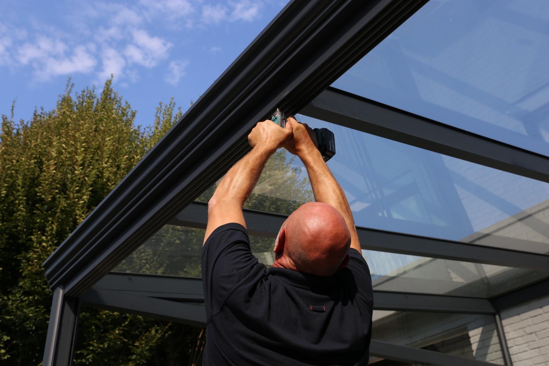 Assembly of a anthracite pergola with a glass roof