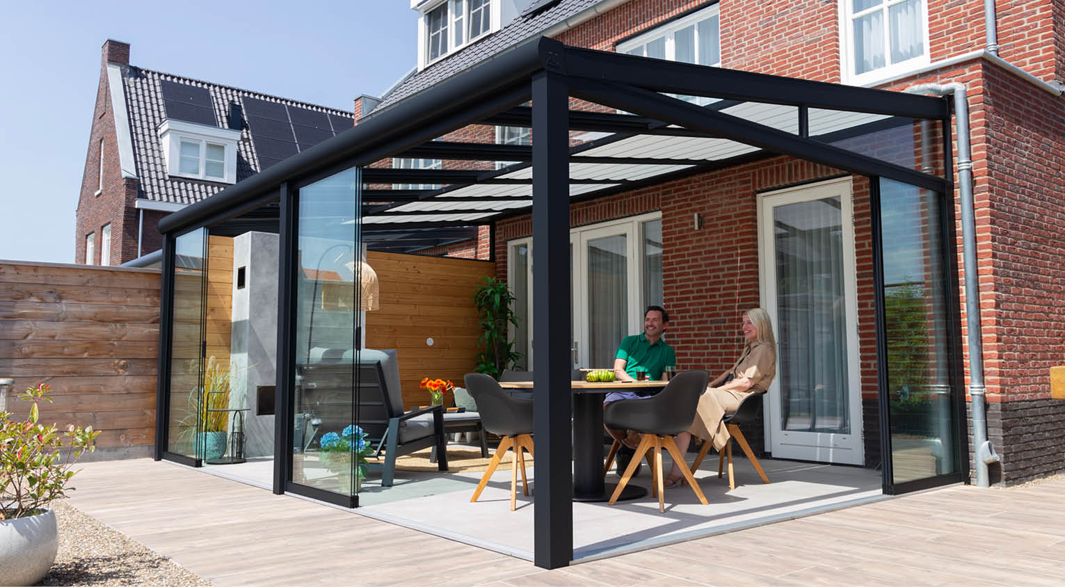 Enjoying together under a matte black veranda from Tuinmaximaal