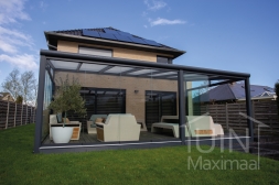 Moderne Gumax Terrasoverkapping in mat antraciet van 7,06 x 4 meter met opaal polycarbonaat dakplaten inclusief Gumax LED verlichting, glazen schuifwanden en Glazen spie