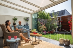 Glass sliding door in white veranda in small garden